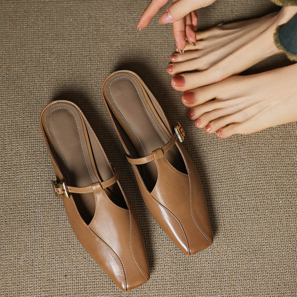 Brown leather mules with open sides, pointed toe, and gold buckle strap, held pair
