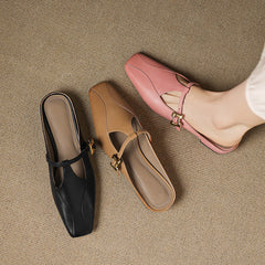 Assorted leather mules in pink, black, and tan, each with gold buckle sling strap