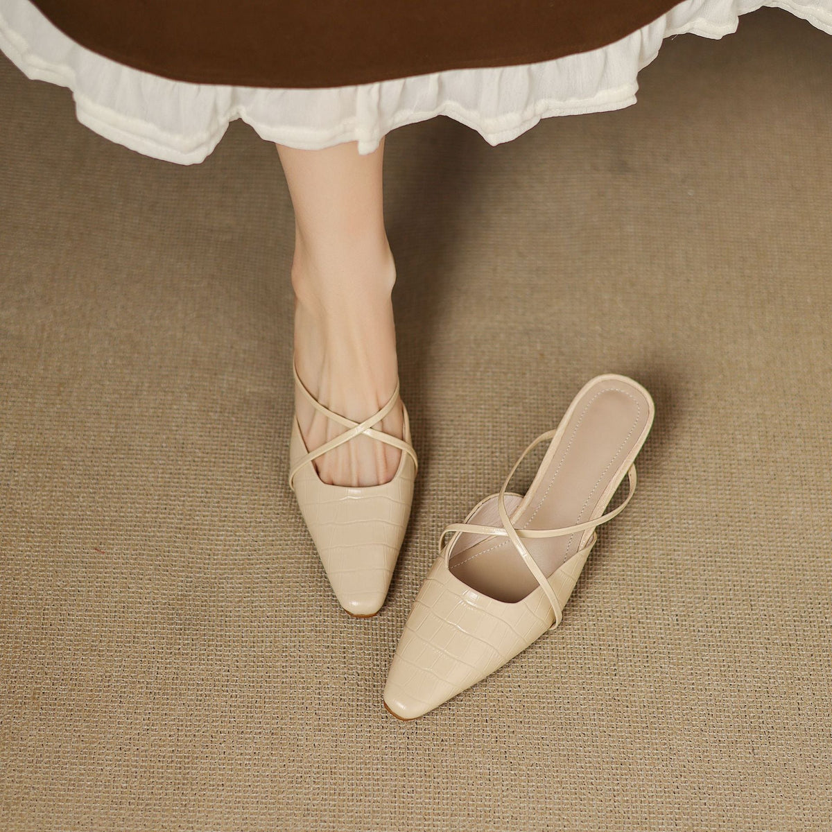 Beige leather mules, crisscross straps and pointed toe with low heel