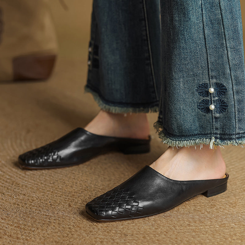 Black leather mule flats with woven toe, low heel, open back