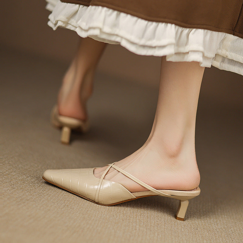 Beige mule shoes with crisscross front straps, pointed toe, and low stacked heel