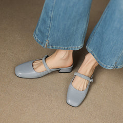Light blue leather Mary Jane mule with elastic strap, buckled detail, and block heel