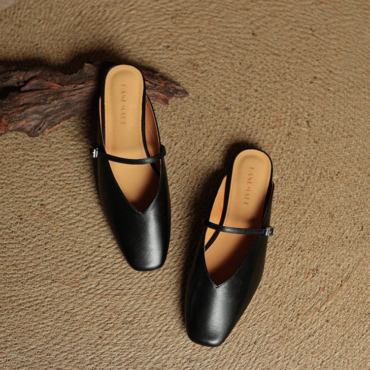 Black leather mule flats with ankle strap, pointed toe, and low heel