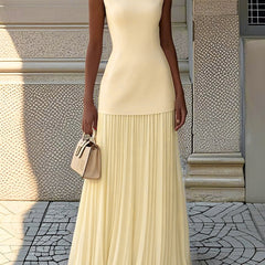 Yellow pleated sleeveless maxi dress with fitted bodice and tiered skirt.
