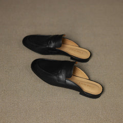 Pair of black genuine leather mules with decorative strap seam and rounded toe