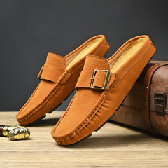 Pair of tan suede mules with metal buckle strap and stitched edges