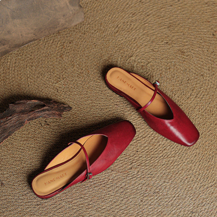 Pair of maroon leather mules with square toe, slingback strap, and buckle closure