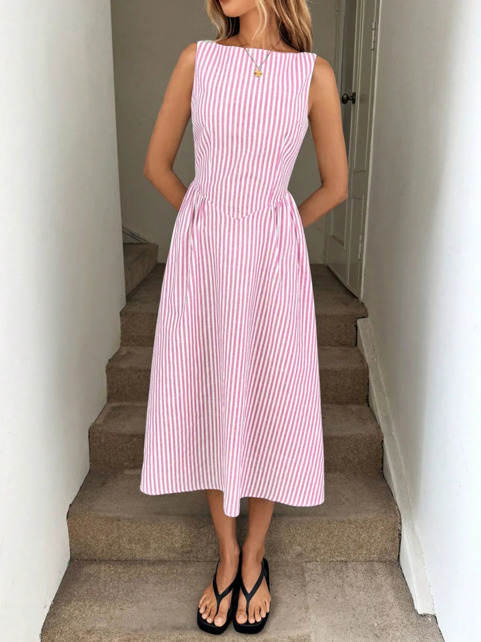 Pink striped sleeveless maxi dress with fitted waist and button detail at chest