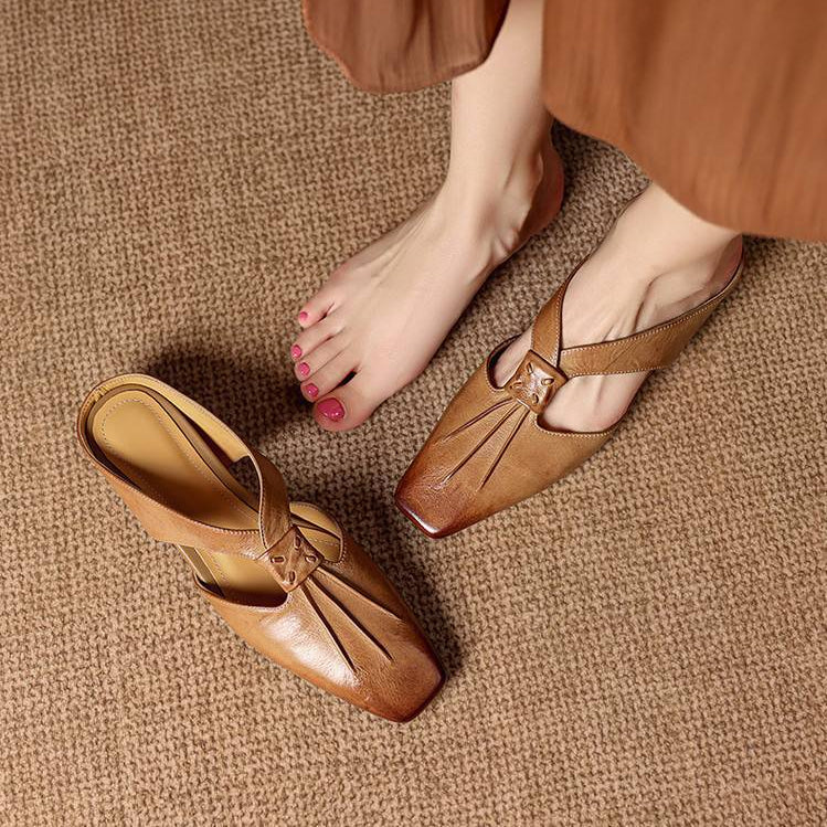 Cognac brown square-toe genuine leather mules with strap and low flat profile.