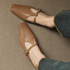 Brown leather mules with ankle strap, cutout vamp, and gold buckle detail