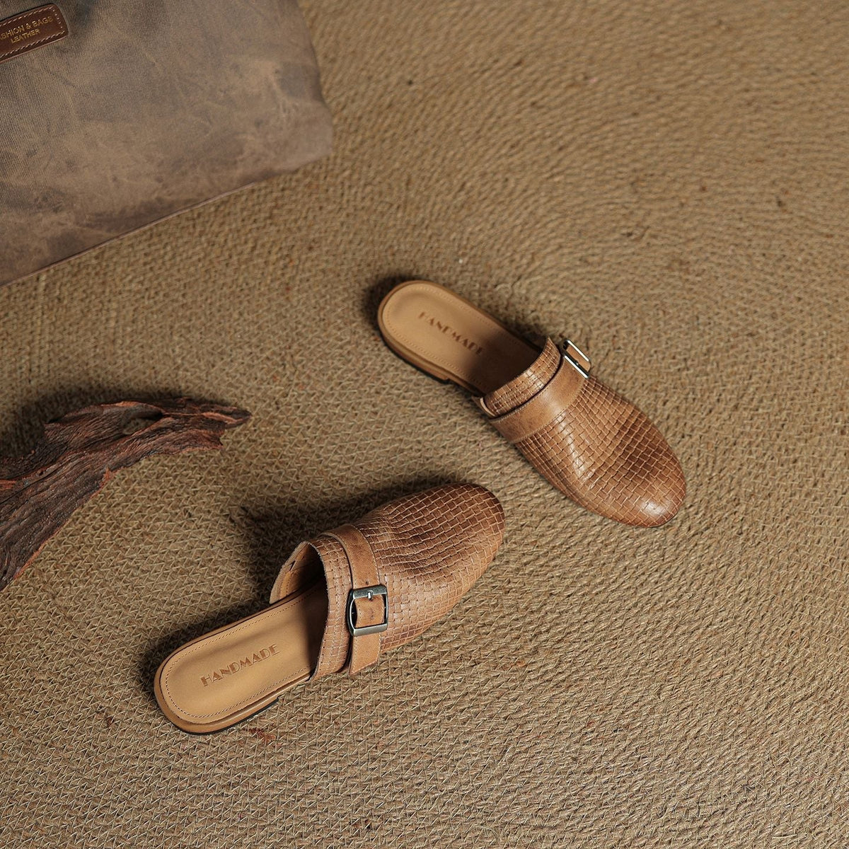 Pair of brown leather mules with buckle strap and slip-on design