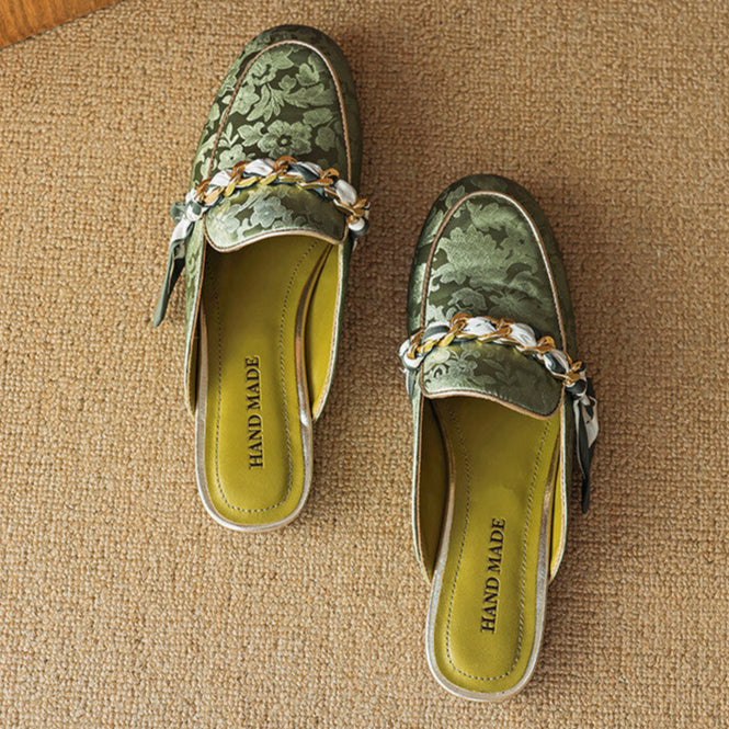 Pair of green genuine leather mules with floral print, braided bow trim, slip-on