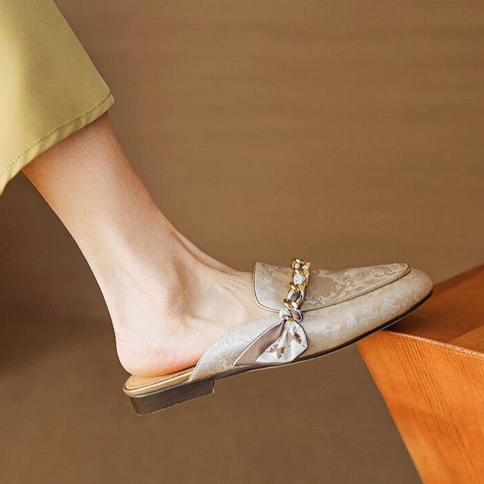 Beige genuine leather mules with floral print, braided bow ornament, low flat sole