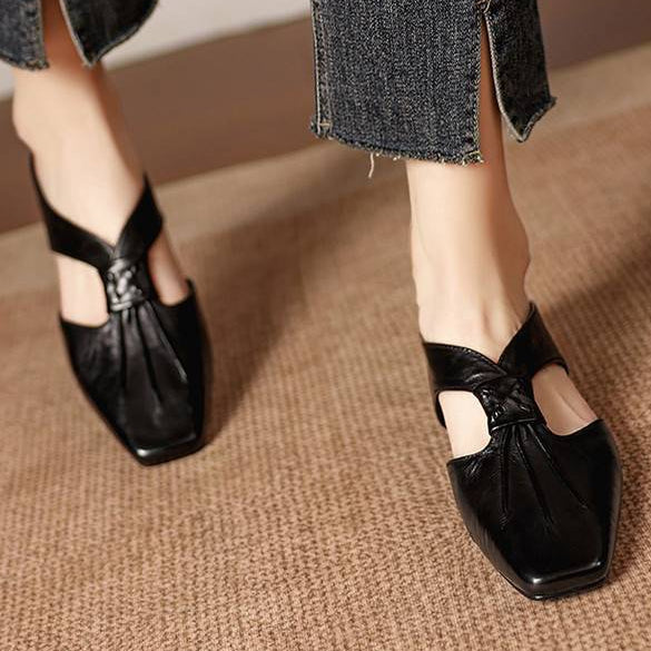 Black square-toe leather mules with knotted bow detail and low heel.