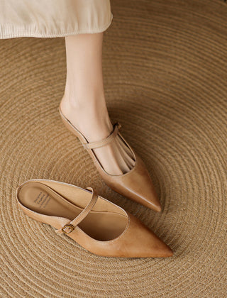 Tan leather mules with pointed toe, slim ankle strap, and buckle detail