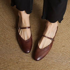 Brown genuine leather ballerina-style mules with cross strap buckle and low heel