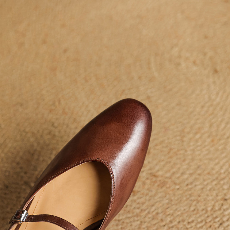 Brown genuine leather mule with open back, strap detail, and almond toe