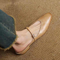 Tan genuine leather mules close-up on foot with double strap and buckle detail