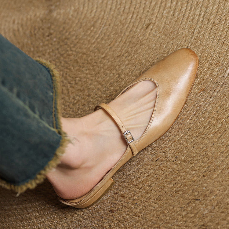 Tan genuine leather mules close-up on foot with double strap and buckle detail