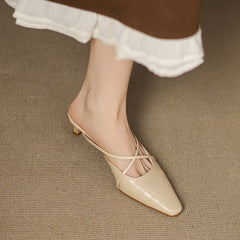 Beige mule with crisscross straps, pointed toe, and low heel on foot