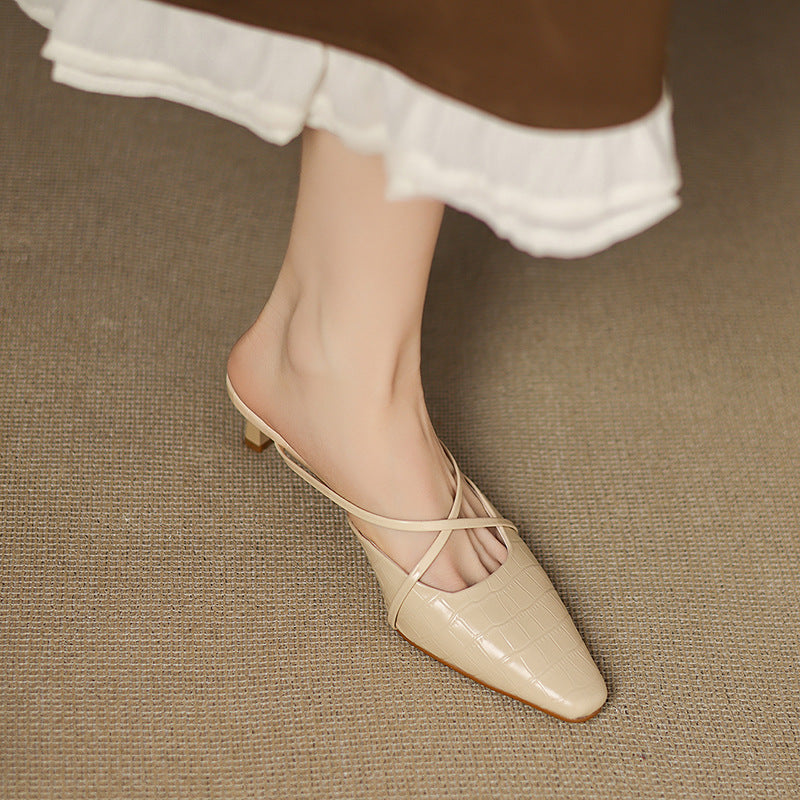 Beige mule with crisscross straps, pointed toe, and low heel on foot