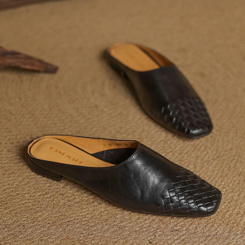 Black genuine leather mules with woven toe detail, slip-on low heel.