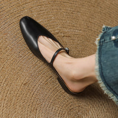 Black leather pointed-toe mules with ankle strap and curved low heel