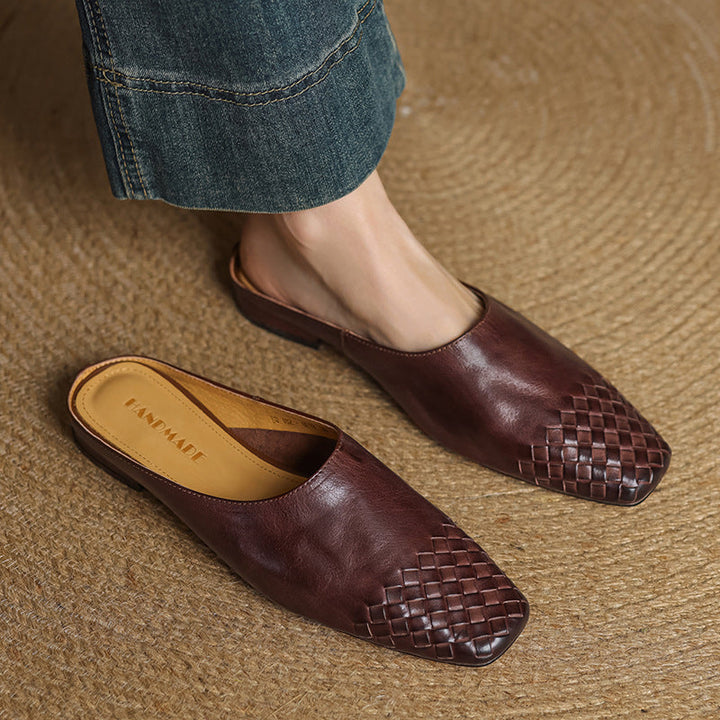 Brown genuine leather mules with woven strap at toe, slip-on flat.