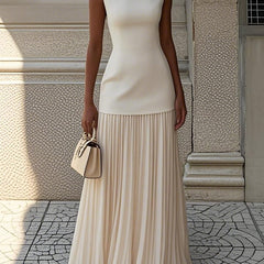 Cream pleated sleeveless maxi dress with fitted bodice and tiered skirt.