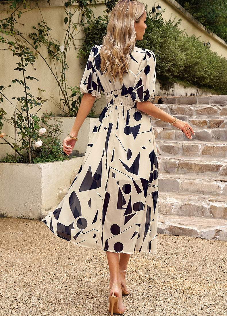 Back view: navy-and-white abstract midi dress with tied waist and short sleeves