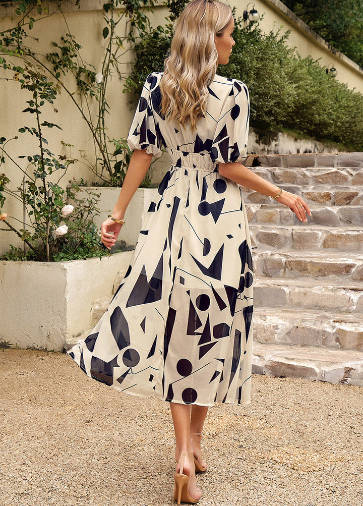 Back view: navy-and-white abstract midi dress with tied waist and short sleeves