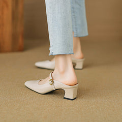 Beige leather slip-on mule showing low block heel and side buckle strap.