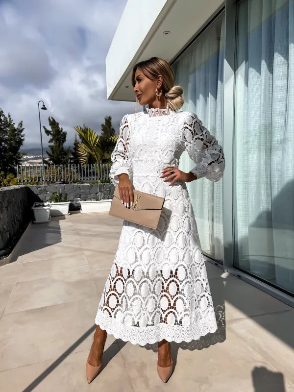 White romantic lace dress with long puff sleeves and scalloped hem, midi length.