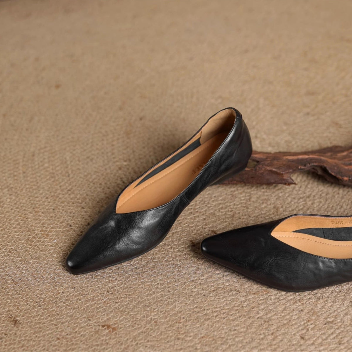 Black leather slip-on mules with pointed toe and V-cut opening, flat low heel.