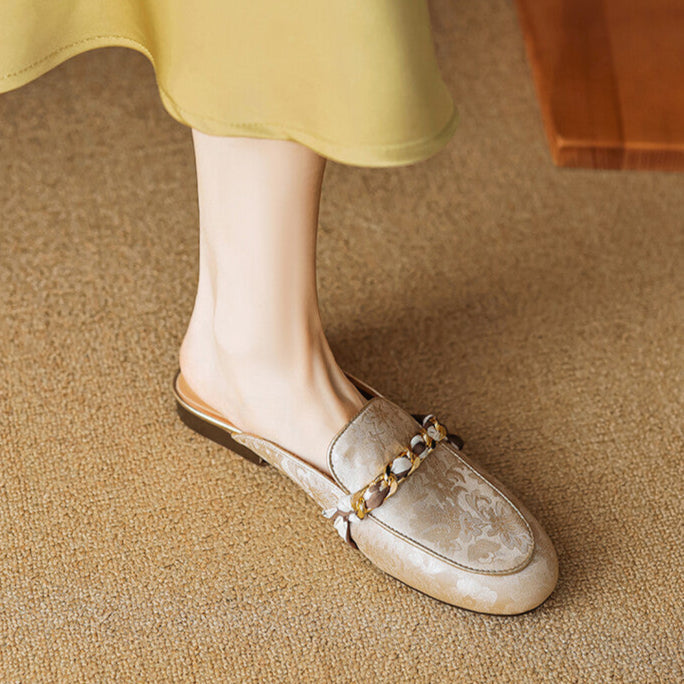 Beige patterned leather mule with gold chain trim and bow detail, slip-on style