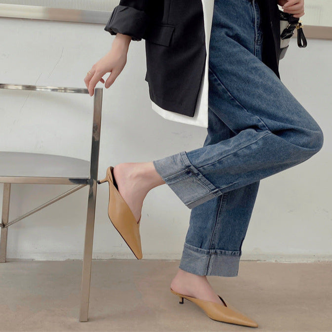 Tan pointed-toe slip-on mules with low heel worn with cuffed jeans