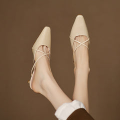 Beige genuine leather mules on model, pointed toe, crisscross straps, low heel