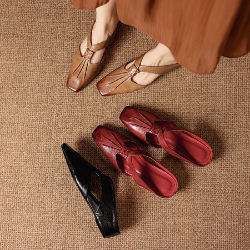 Square-toe leather mules in gold, black, and red tones with bow detail.