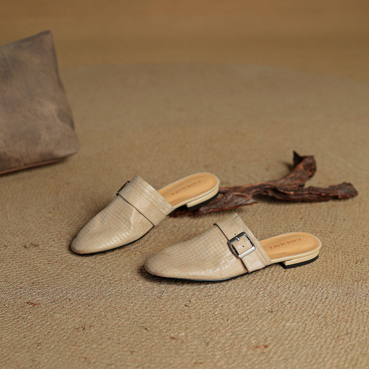 Beige leather mules with square buckle strap, one shown with backless profile