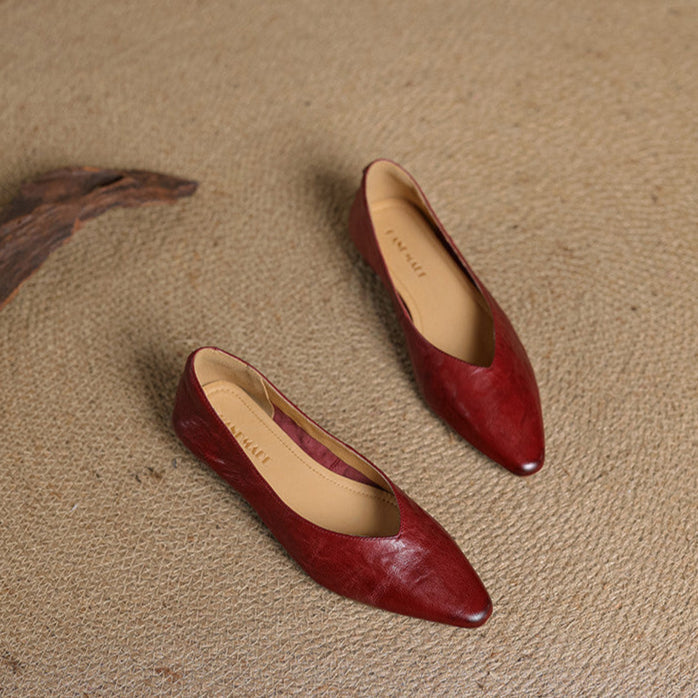 Pair of maroon leather pointed-toe mules with beige insoles, side-by-side view