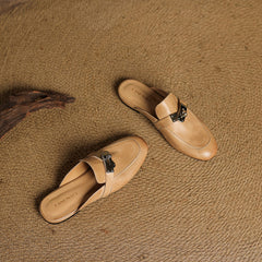 Tan leather mules with square toe and silver buckle strap, side view
