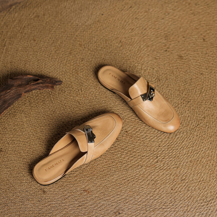 Tan leather mules with square toe and silver buckle strap, side view