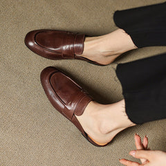 Brown leather mules with low profile sole and strap detail across the top