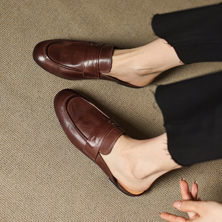 Brown leather mules with low profile sole and strap detail across the top