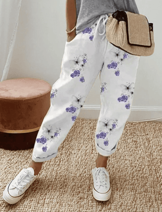White cotton trousers with purple floral print, elastic waist and cuffed hems