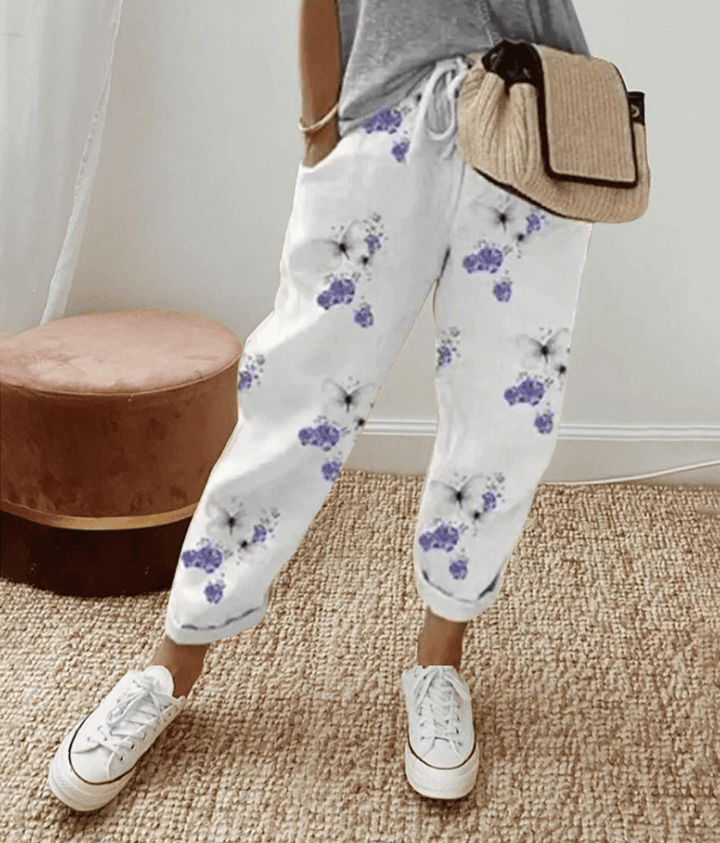 White cotton trousers with purple floral print, elastic waist and cuffed hems
