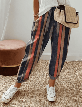 Dark cotton trousers with vertical navy, red, and tan stripes, elastic waist