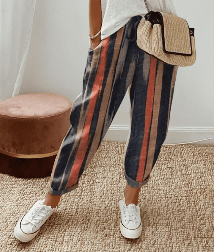 Dark cotton trousers with vertical navy, red, and tan stripes, elastic waist