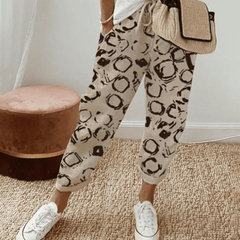 Beige cotton trousers with black circular print, elastic waist and cuffed hems