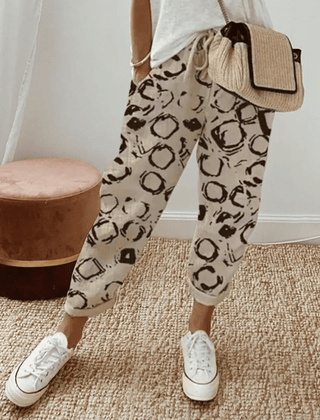 Beige cotton trousers with black circular print, elastic waist and cuffed hems